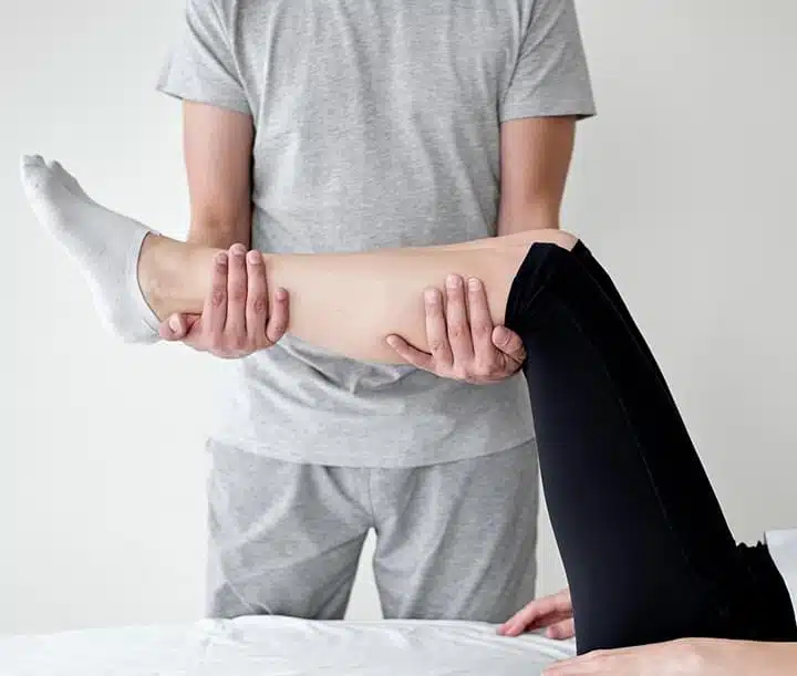 Therapist performing precise calf stretching for muscle recovery. Supportive treatment for back adjustment London and improved mobility.