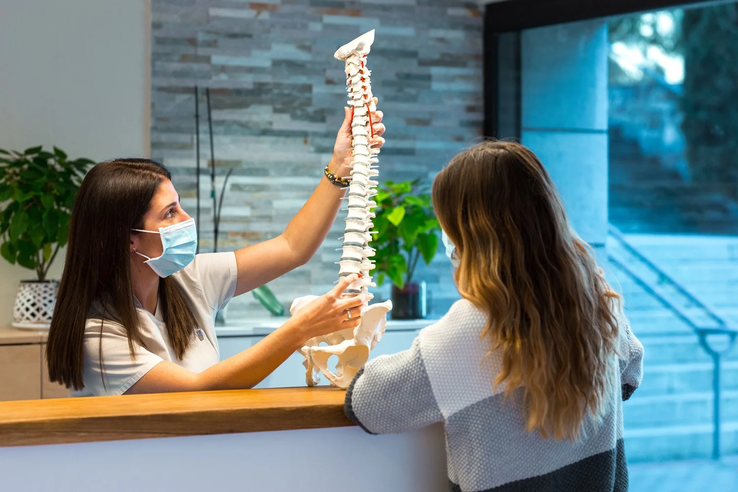 Doctor explaining slipped disc condition to patient using a spine model.