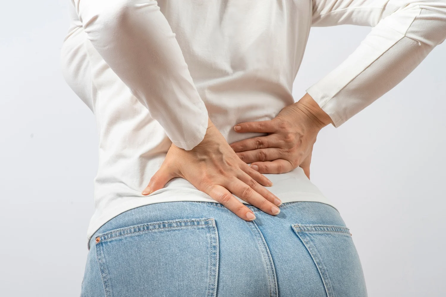Young woman experiencing sudden lower back pain – common neuralgia symptoms.